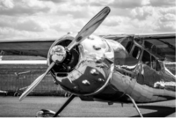 prop taildragger next to hangar